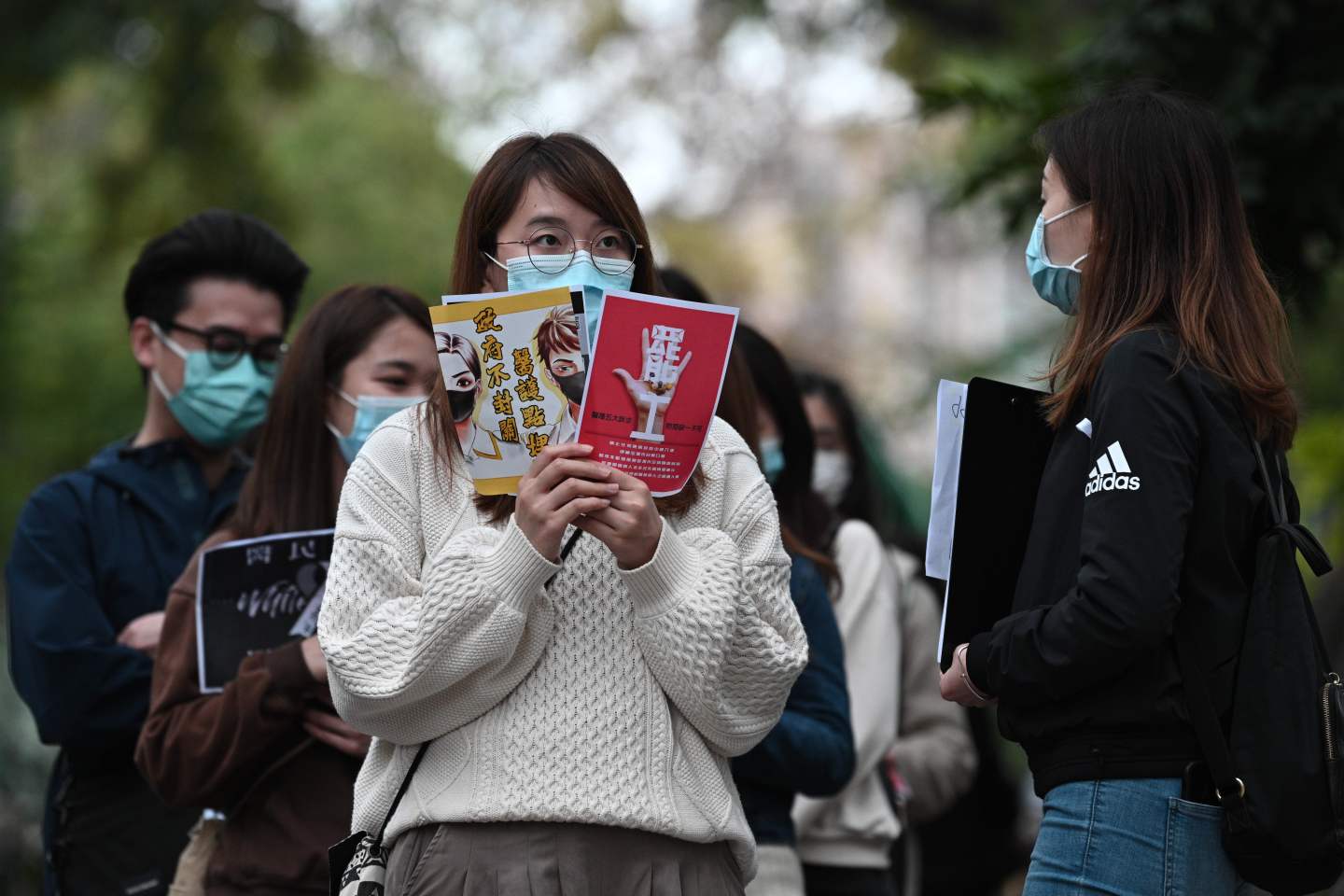 Staff members of Hong Kong's Hospital Authority, which employs 75,000 people citywide, queue up to sign a letter of petition in support of a planned strike by hospital workers calling for the full closure of border crossings from mainland China, near the Queen Elizabeth hospital in Hong Kong on February 4, 2020. - Hong Kong on February 4 become the second place outside of the Chinese mainland to report the death of a patient being treated for a new coronavirus that has so far claimed more than 400 lives. (Photo by Anthony WALLACE / AFP) (Photo by ANTHONY WALLACE/AFP via Getty Images)