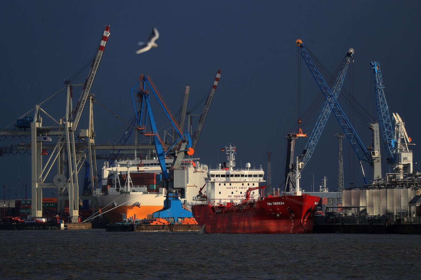 Chemical and oil tanker Tina Theresa, right, sits docked near shipping cranes at the port of Hamburg in Hamburg, Germany, on Wednesday, Feb. 12, 2020. Germany's biggest bank has given the strongest warning yet that the nation is close to a recession as the coronavirus outbreak exacerbates its long-running industrial slump. Photographer: Krisztian Bocsi/Bloomberg via Getty Images