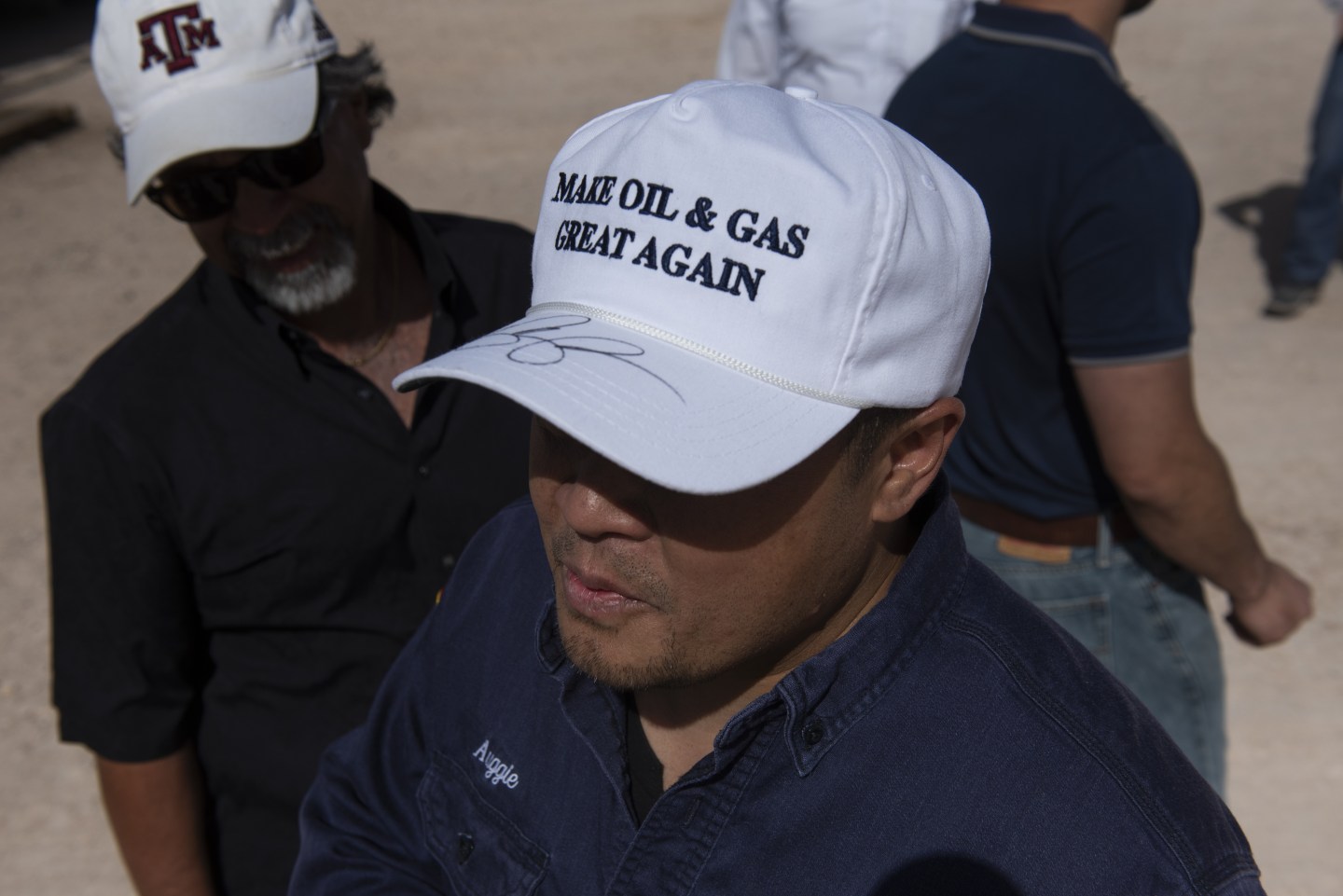 An employee wears a hat signed by U.S. Vice President Mike Pence during his tour of a Diamondback Energy oil rig in Midland, Texas, on April 17, 2019. Monday's oil price plunge prompted companies like DiamondBack, a player in the Permian basin at the heart of the U.S. shale boom, to immediately announce cuts in production and activity.