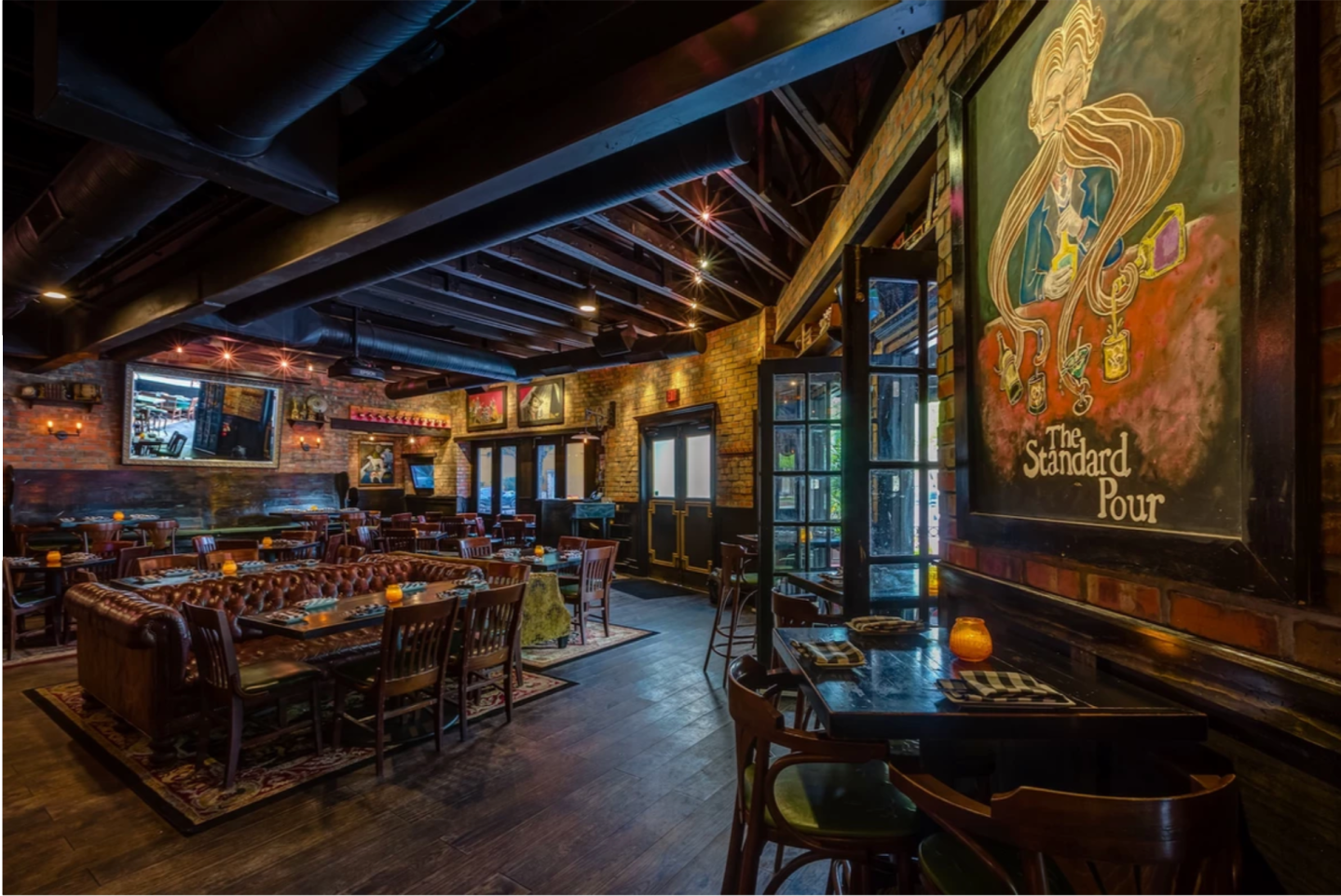 A painting inside dallas bar, The Standard Pour, a paint depicts a man using his beard to mix drinks.