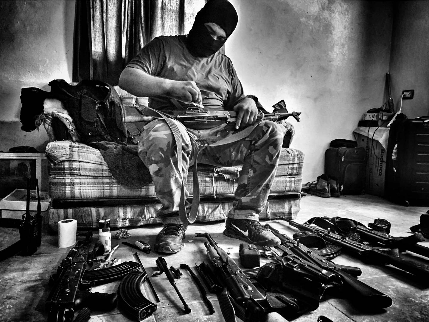 A Sinaloa Cartel member cleans guns.