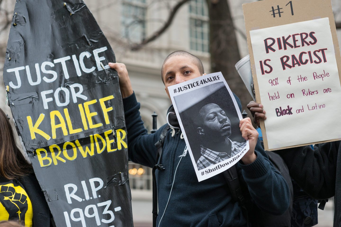 Demonstrators hold aloft a symbolic coffin bearing Kalief