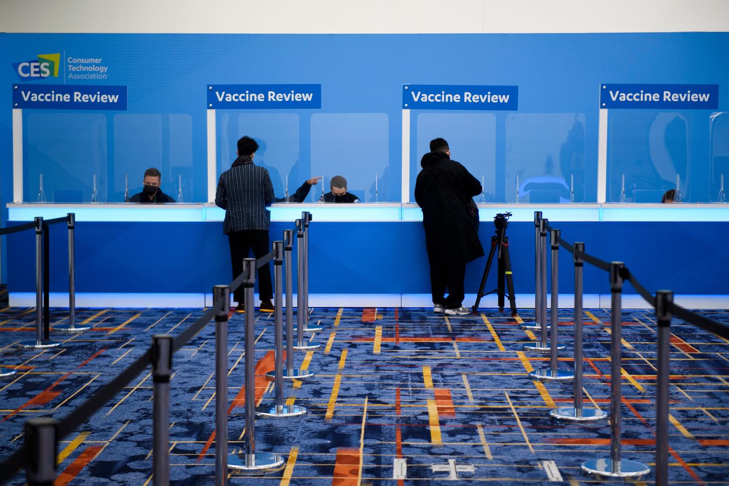 Attendees have their COVID-19 vaccination cards reviewed in order to receive their badges ahead of CES Las Vegas.