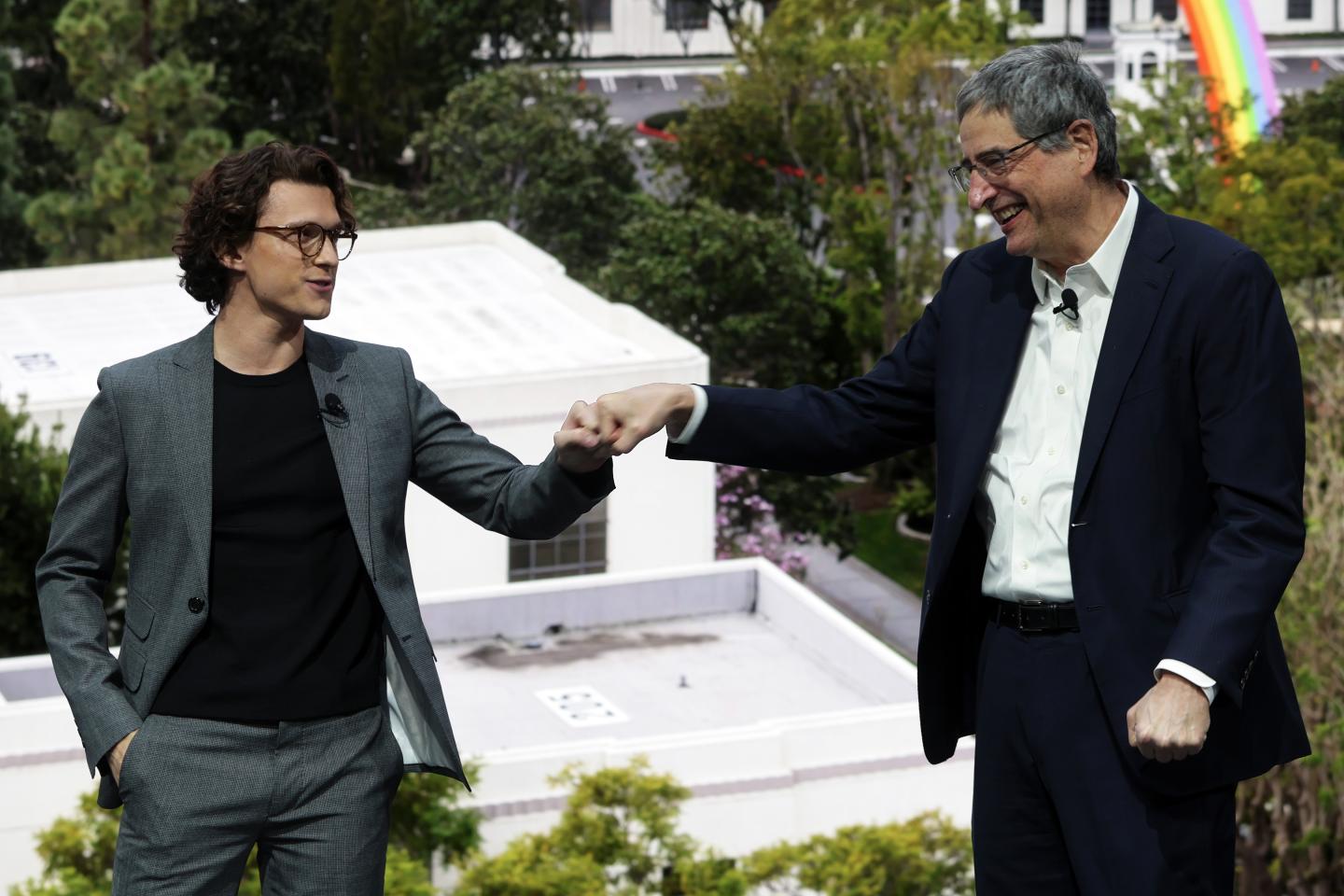 Chairperson of Sony Pictures Entertainment Thomas Rothman (R) and actor Tom Holland (L) greet each other with a fist-bump during a Sony press event