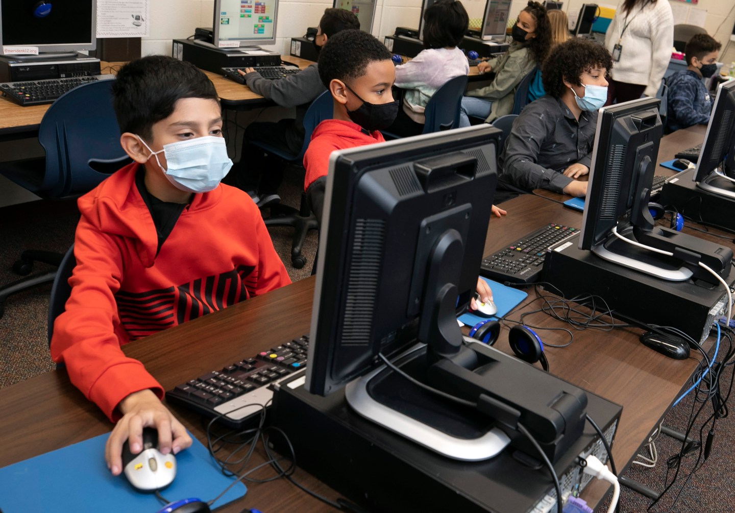 Masked students working in a computer lab