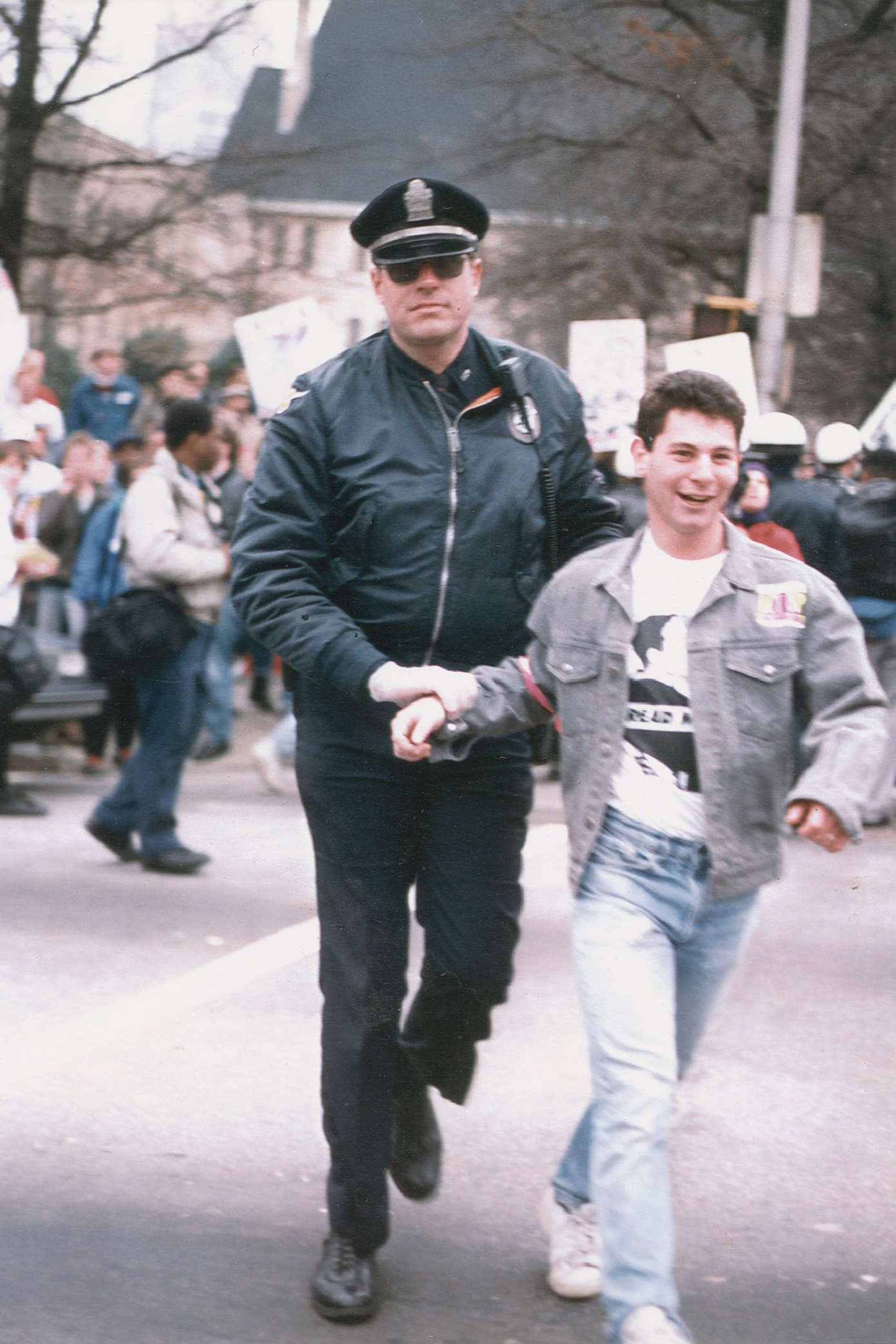 young man escorted by policeman