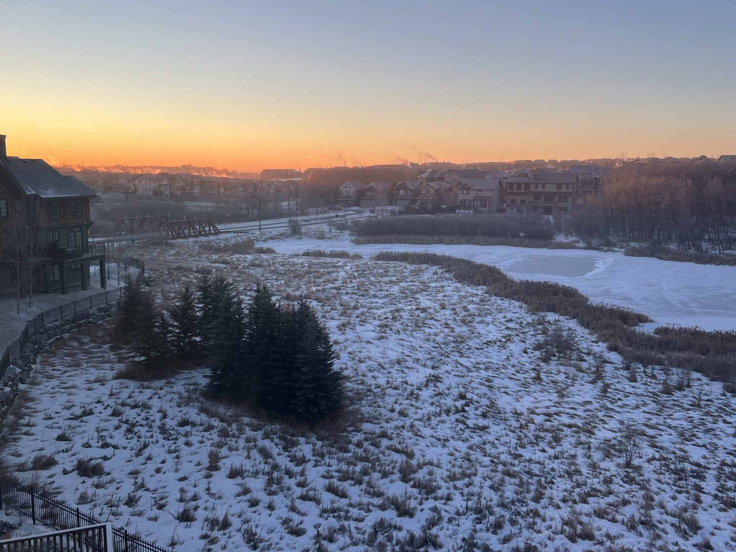 A snow-covered landscape at sunset in Calgary, Alberta, Canada at sunrise in February, 2022.