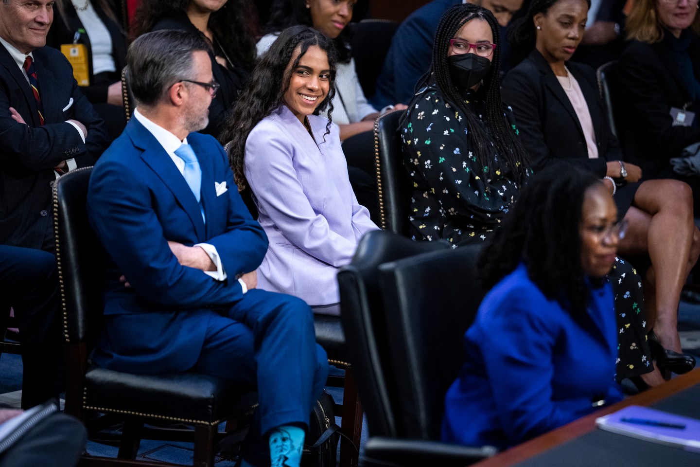 Judge Ketanji Brown Jackson speaks during her Supreme Court nomination while her daughter Leila and husband Patrick smile.