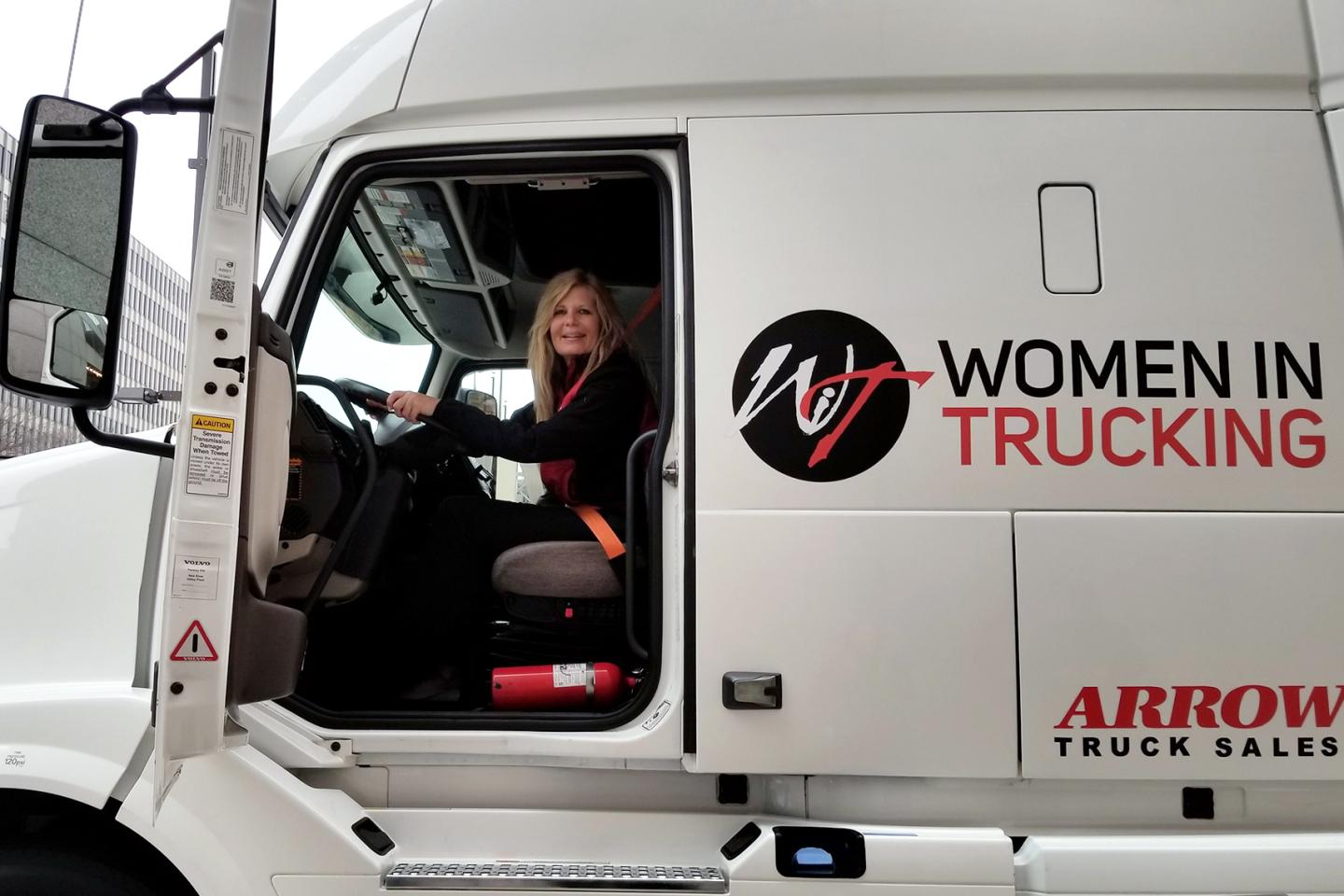 Ellen Voie, founder of Women in Trucking, sits in a truck.