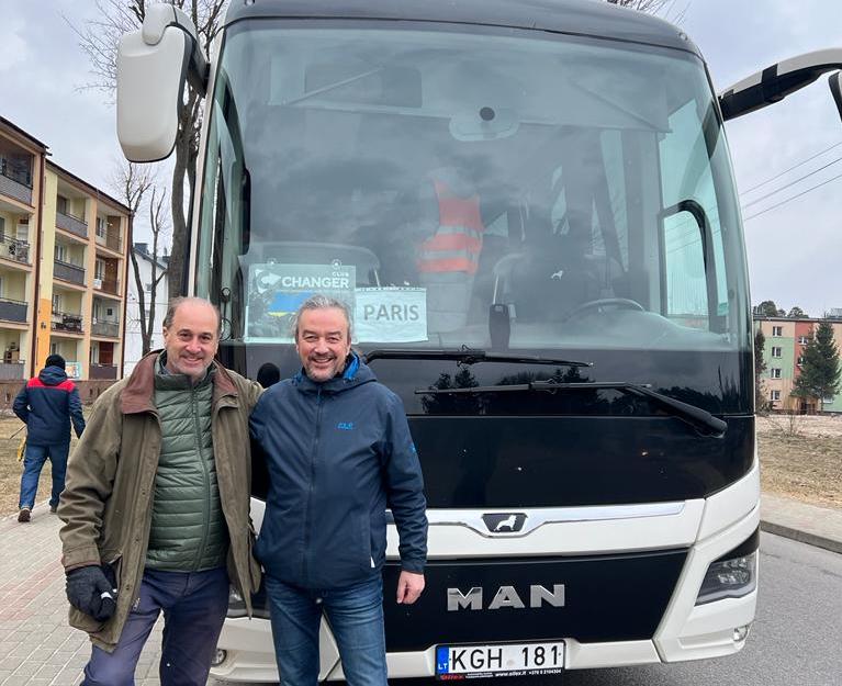 Brooks Newmark (left) and Raitis Bullits in Tomaszow Lubelski on the Polish border with one of the buses.