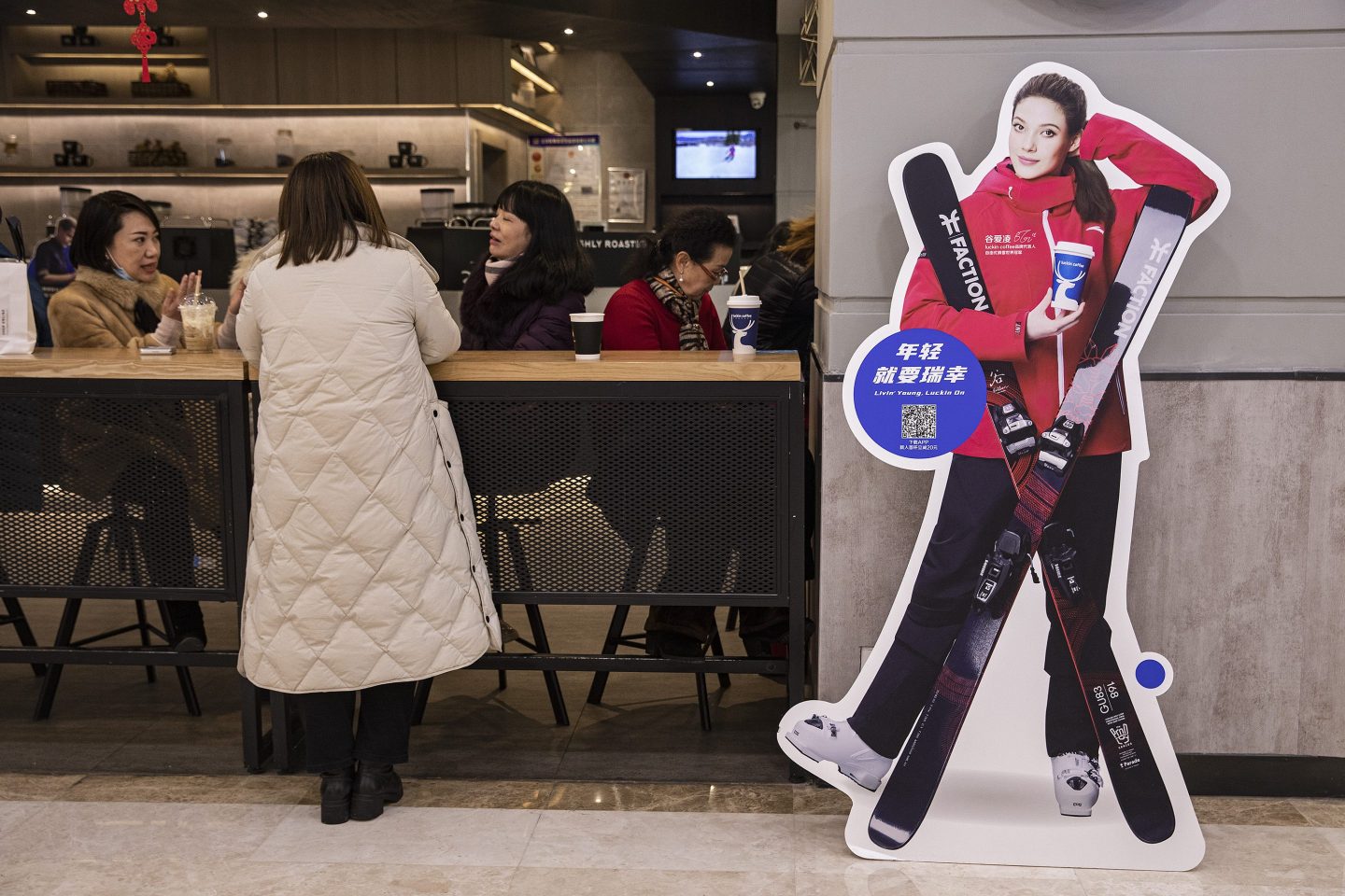 A cardboard cutout of Olympic athlete Eileen Gu holding a Luckin Coffee cup