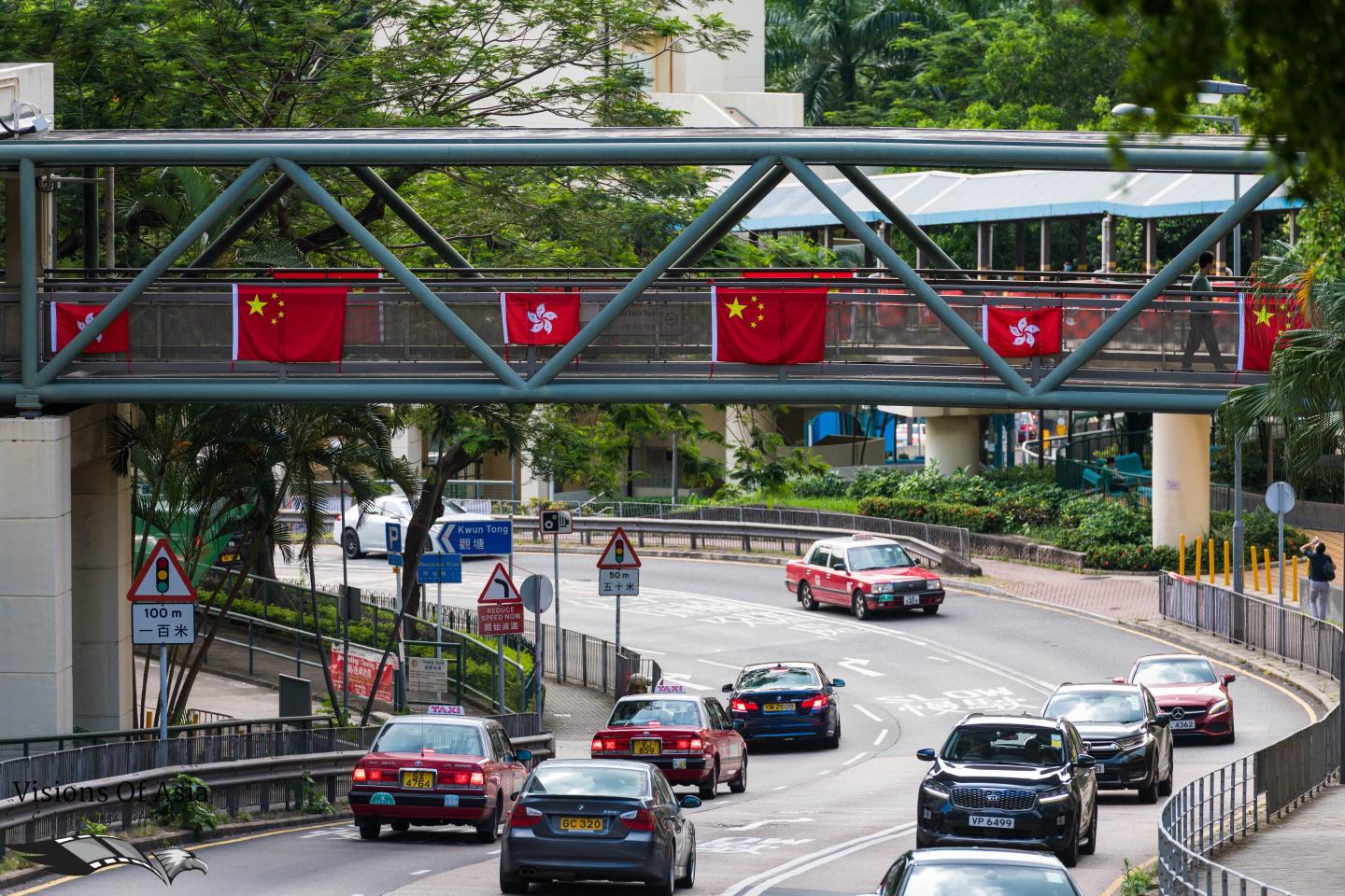 Chinese and Hong Kong flags adorn a walkway in Hong Kong.