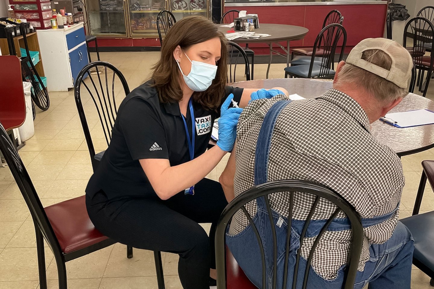 pharmacist gives a vaccine to a rural farmer