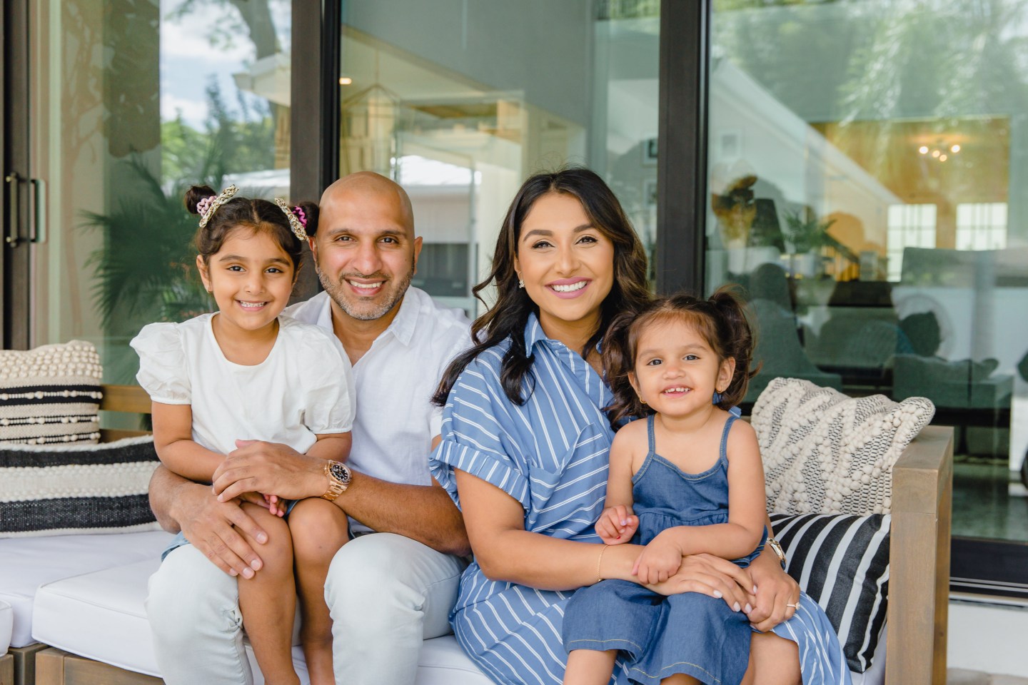 Stax founder and CEO Suneera Madhani sitting with her husband and two daughters.