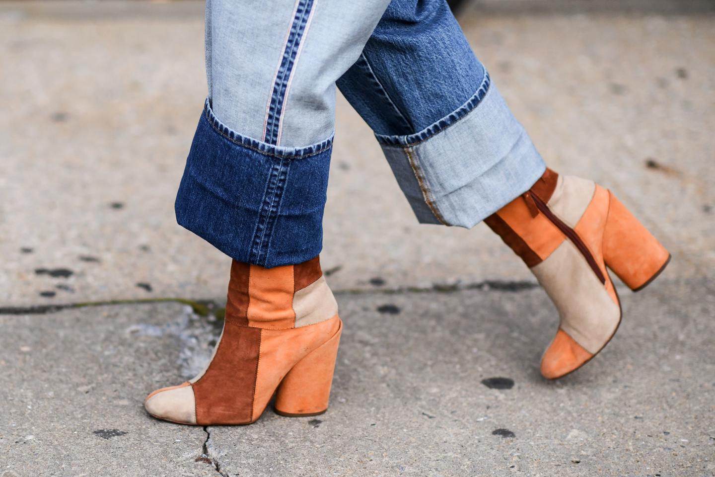 A woman wearing straight leg jeans and boots.