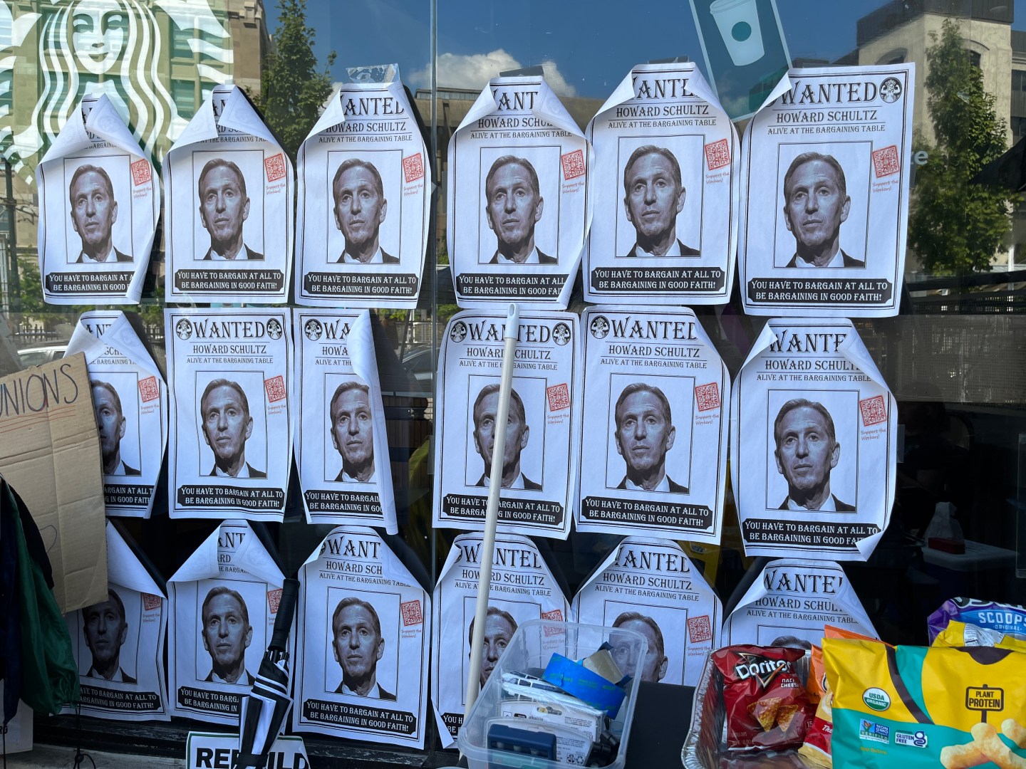 Posters outside of the store, with Starbucks CEO Howard Schultz's face in black and white and text that says "WANTED, HOWARD SCHULTZ, ALIVE AT THE BARGAINING TABLE, YOU HAVE TO BARGIN AT ALL TO BE BARGAINING IN GOOD FAITH"
