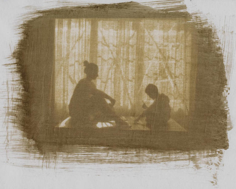 woman and child sitting next to window