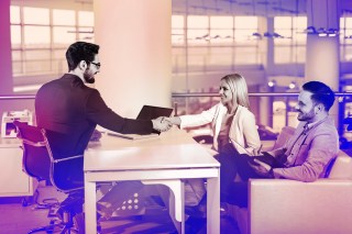 Young couple shaking hands with a banker