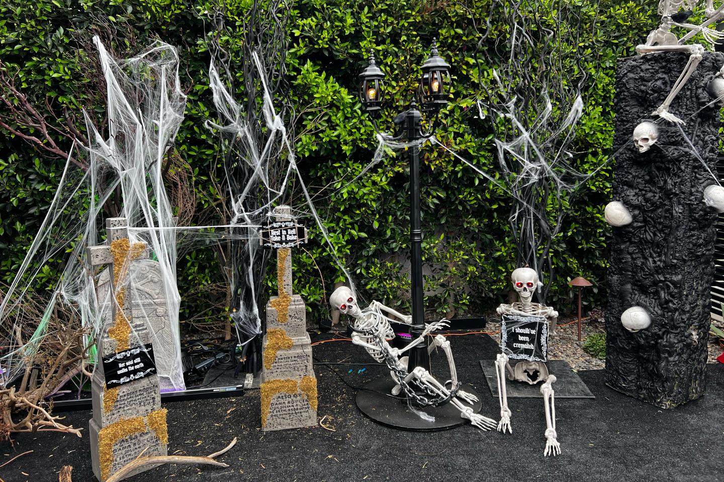Fake skeletons sitting next to fake gravestones.