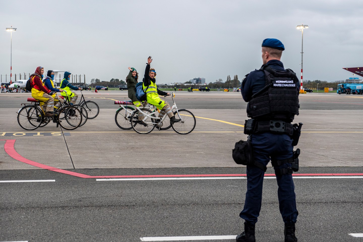 Climate activists ride bikes at Amsterdam Schiphol Airport to protest the use of private jets