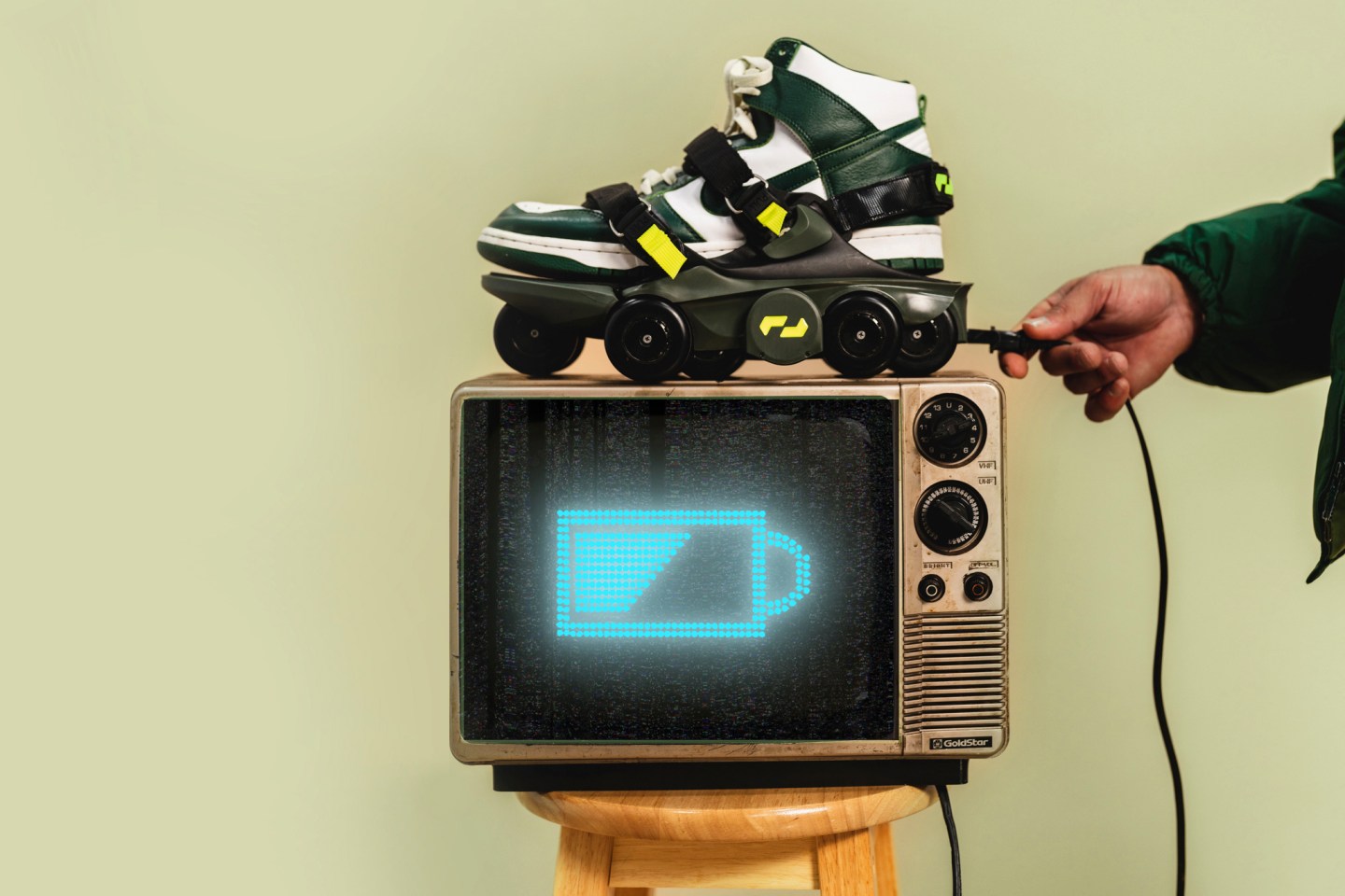 Person plugs in Shift Robotics Moon Walker shoes to charge.