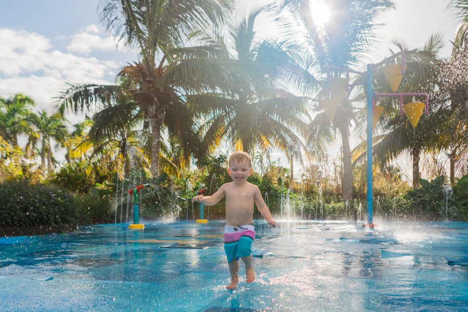 Toddler enjoys splash pad at Lopesan Costa Bávaro Resort Spa & Casino in Punta Cana, Dominican Republic.
