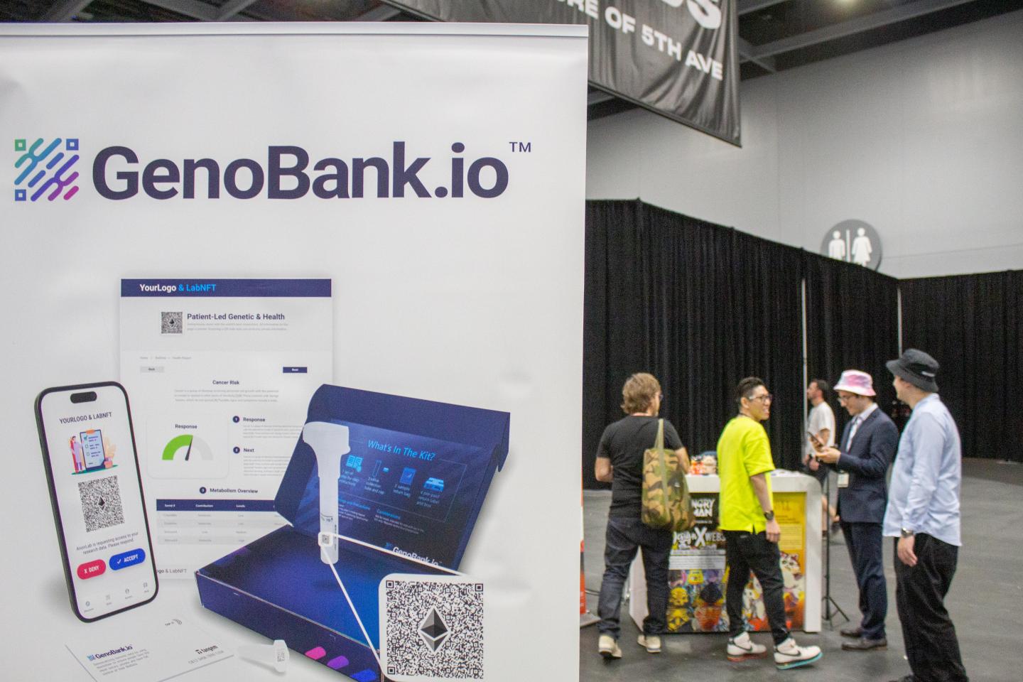 The GenoBank.io sign juxtaposed to a group of people behind it.