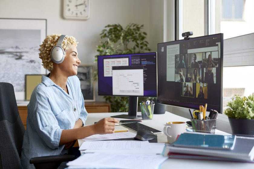 Cheerful businessman working from home while watching video conference on computer monitor