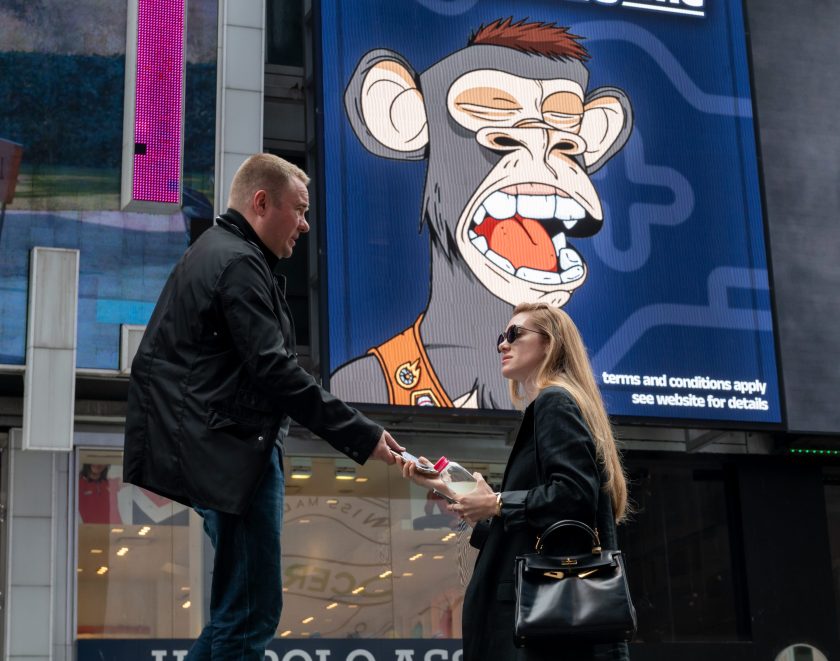 People walk by a Bored Ape Yacht Club NFT billboard in Times Square