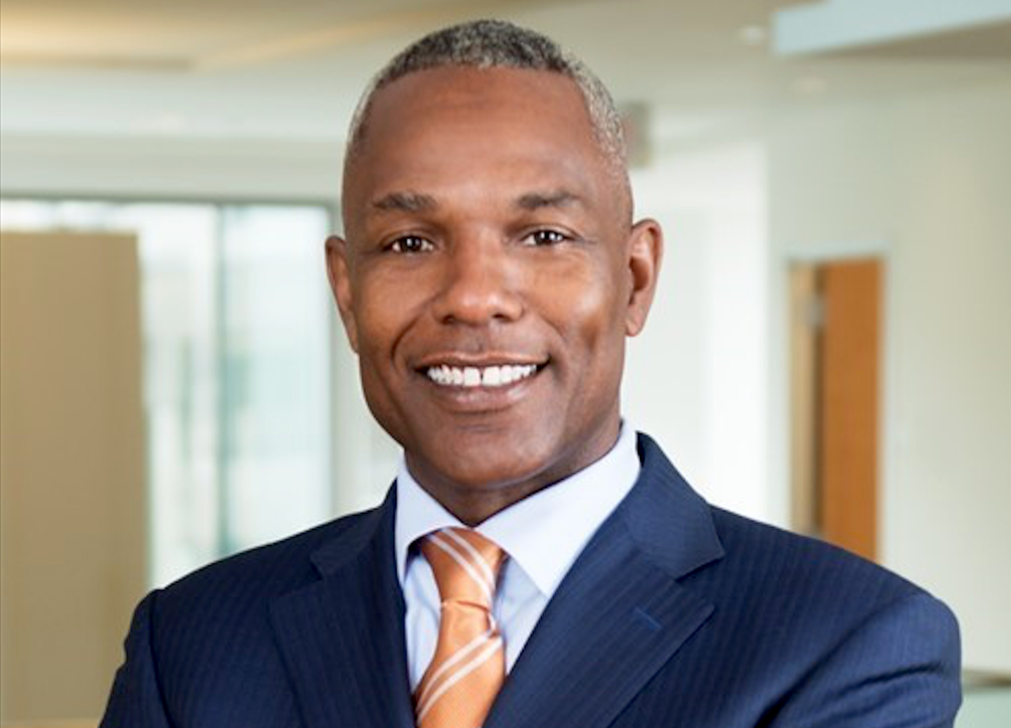 man in suit and orange tie smiling