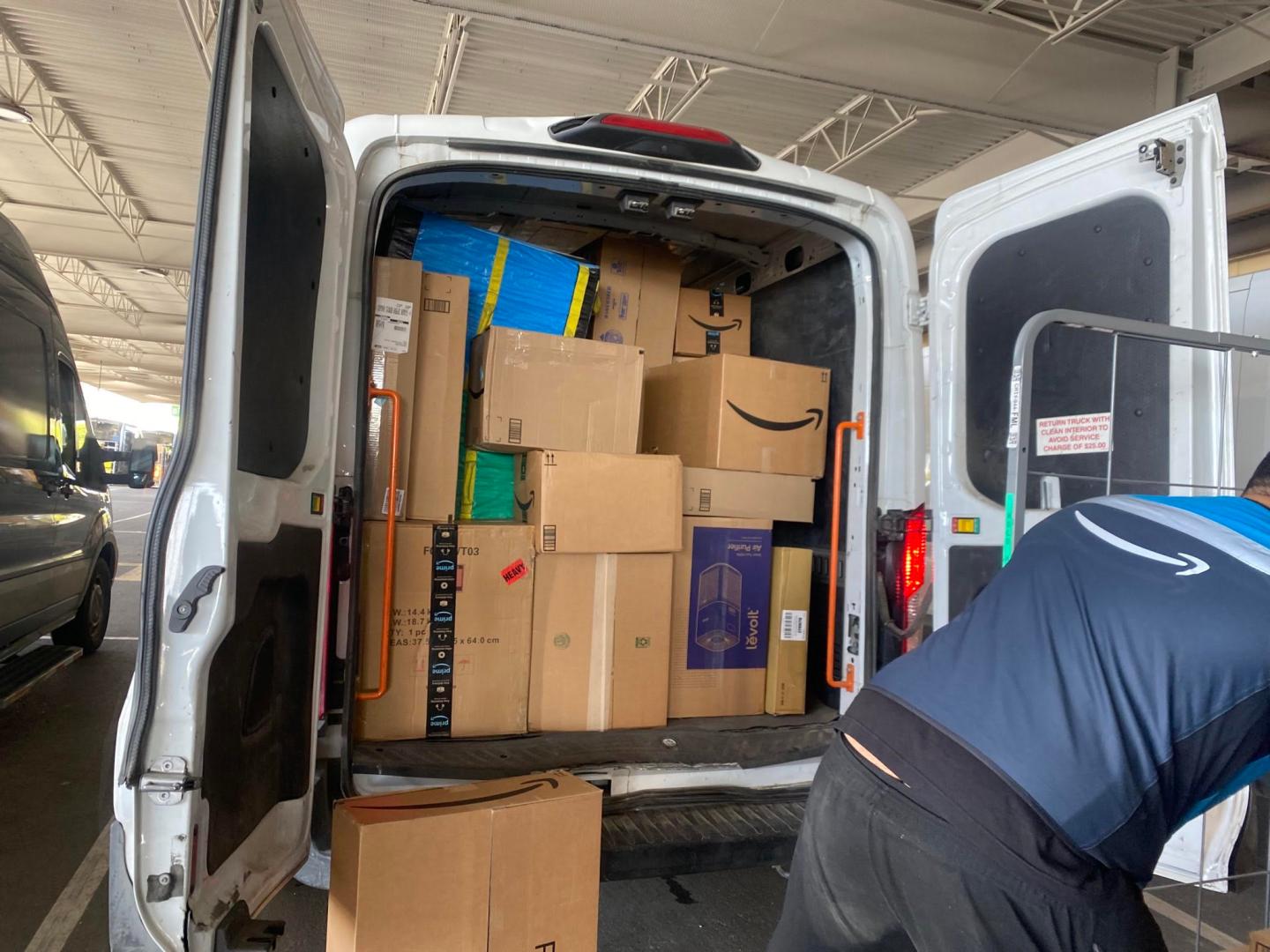 The back of a delivery van stuffed full with Amazon boxes.