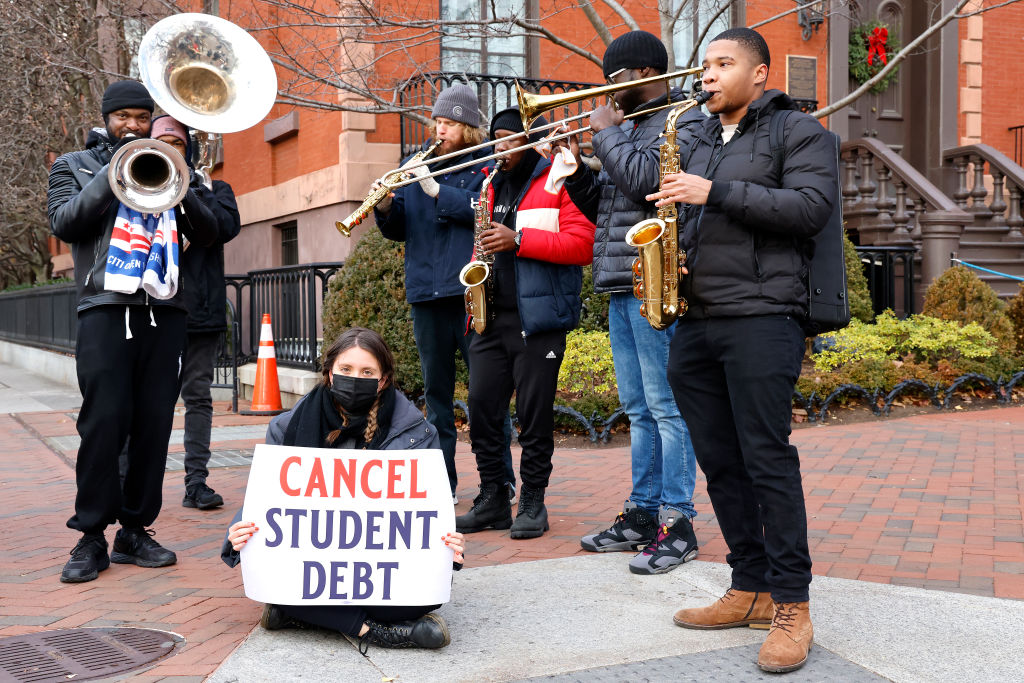 Activists and artists call on President Biden to cancel student debt near the White House, as seen in December 2021 in Washington, DC.