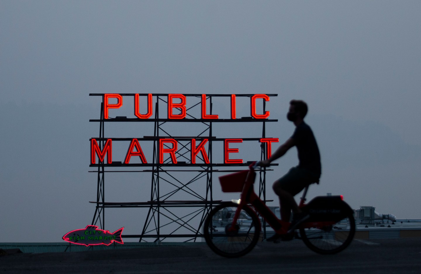 A person bikes past a Pike Place Market sign on Sept. 11, 2020, in Seattle