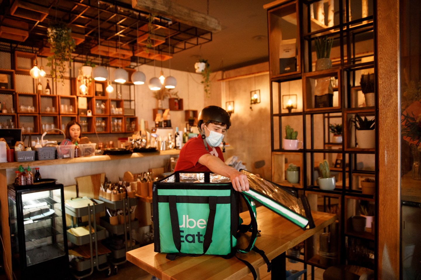 A driver for Uber Eats picks up food at a restaurant in Berlin