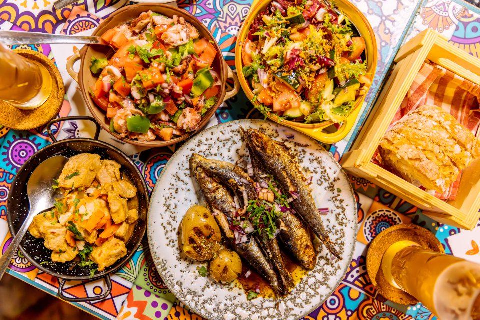 Traditional Portuguese dinner with griller sardines and octopus salad, overhead view