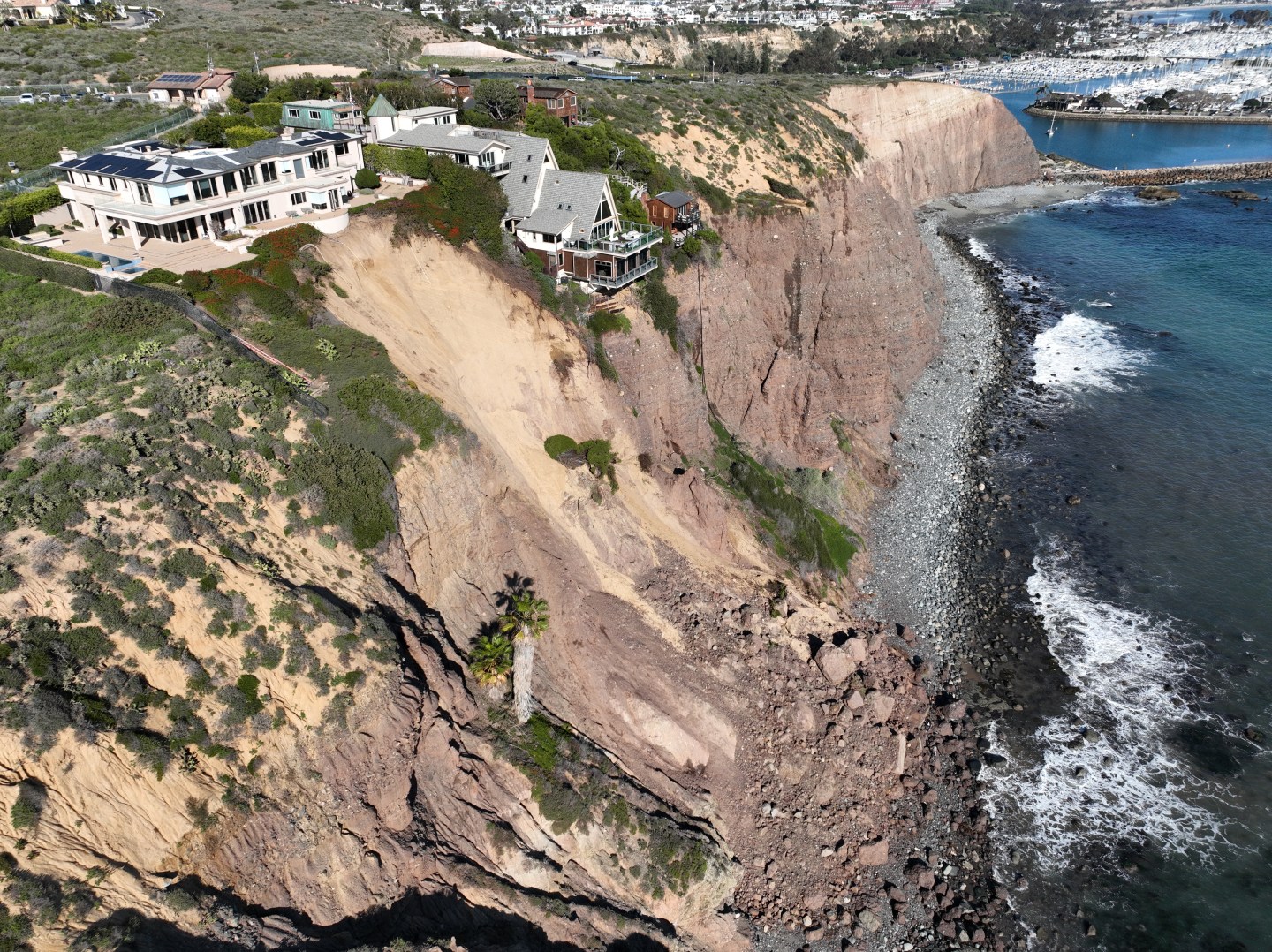 A side view of houses in Dana Point, California, overlooking a cliffside