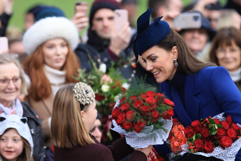 a picture of kate middleton smiling with crowds around her